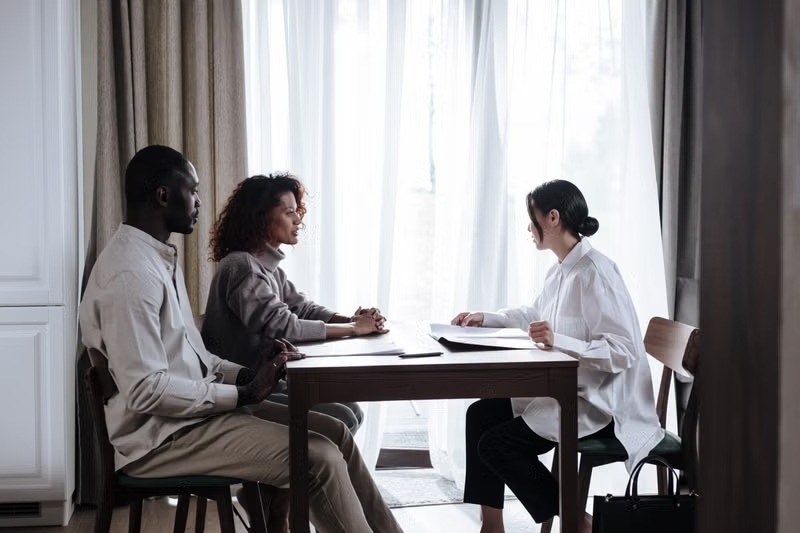 Advisor meeting a couple at a bright table